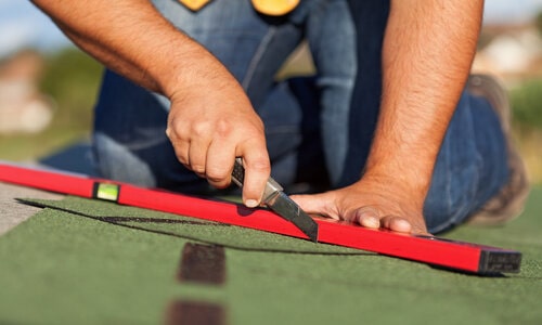 Kitchener Affordable Roofing employee replacing shingles