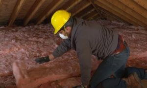 Kitchener Affordable Roofing worker installing insulation